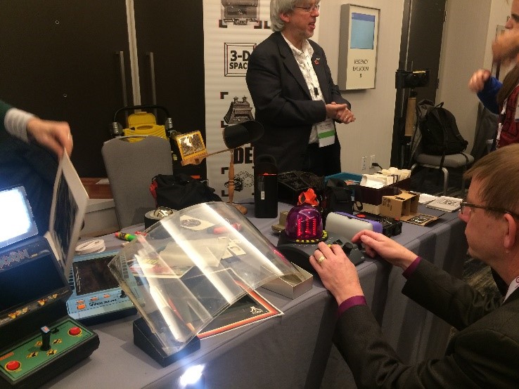 The demo session is always accompanied by a number of interesting discussions. Moreover, this photo contains three Google VR cardboards / HMDs – find them all!  In the mid-frame is Andrew Woods in discussion with Guarav Sharma.